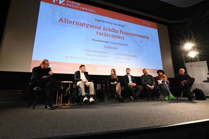 Paneliści Forum Kreatywności na tle prezentacji zapowiadającej panel o alternatywnych źródłach finansowania twórczości