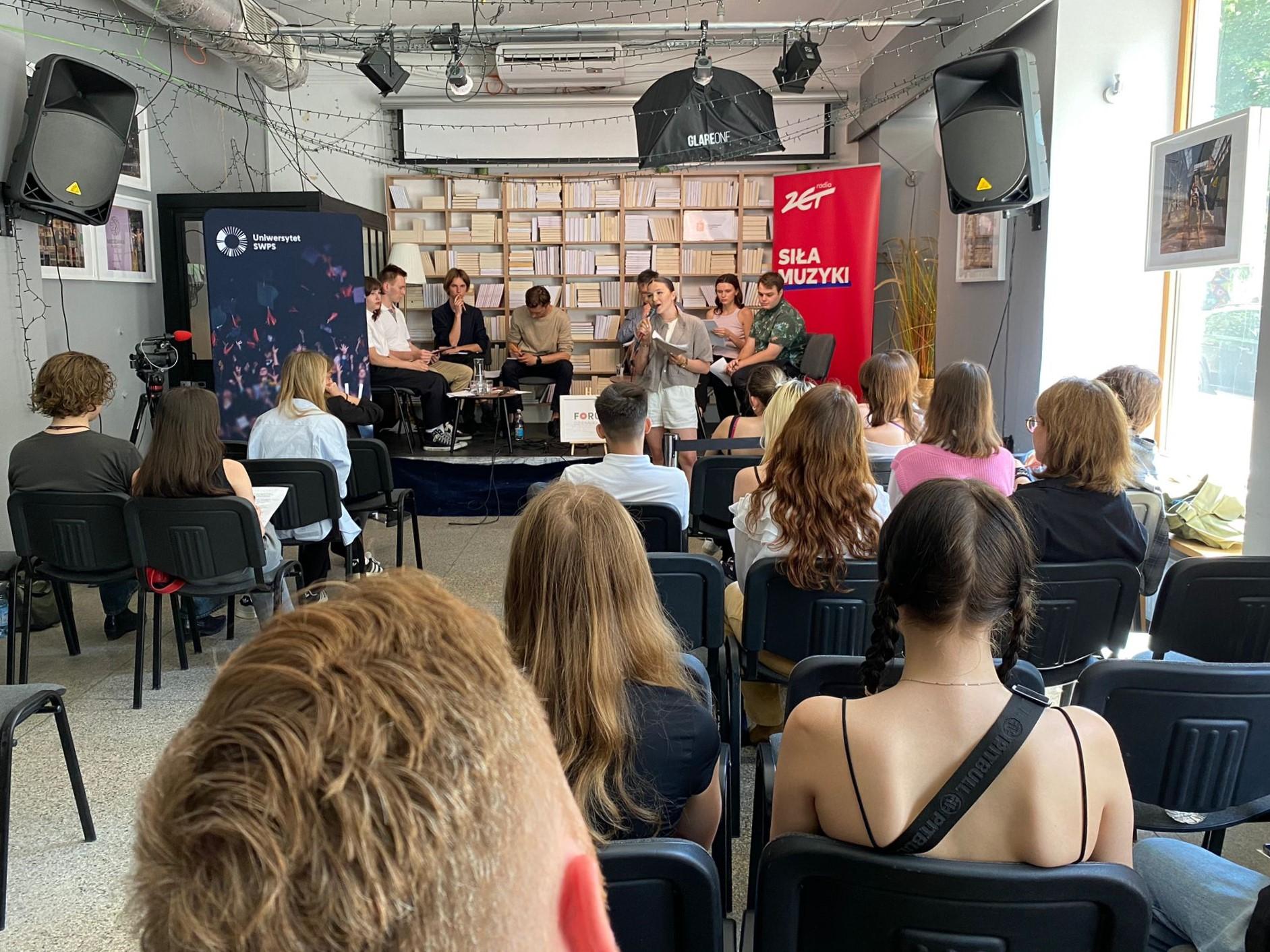 Debata oksfordzka podczas II Forum Dziennikarskiego. Uczestnicy siedzą na krzesłach na scenie, na pierwszym planie publiczność.