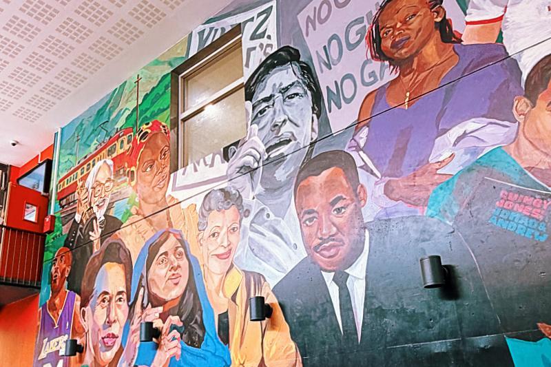 Mural na ścianie restauracji przedstawiający grupę aktywistów politycznych różnych narodowości