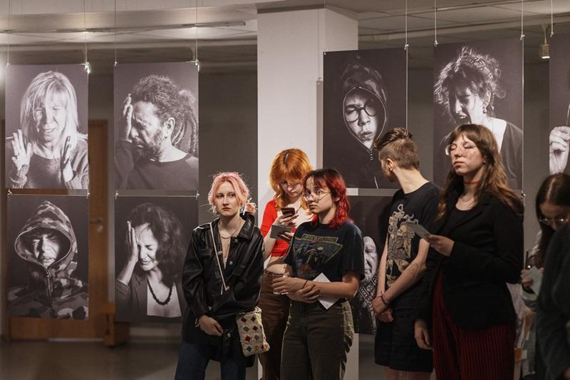 Grupa studentek na tle wystawionych fotografii