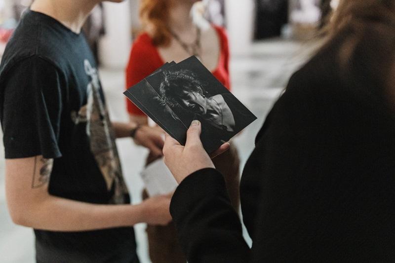 Dłoń trzymająca miniaturki fotografii z wystawy
