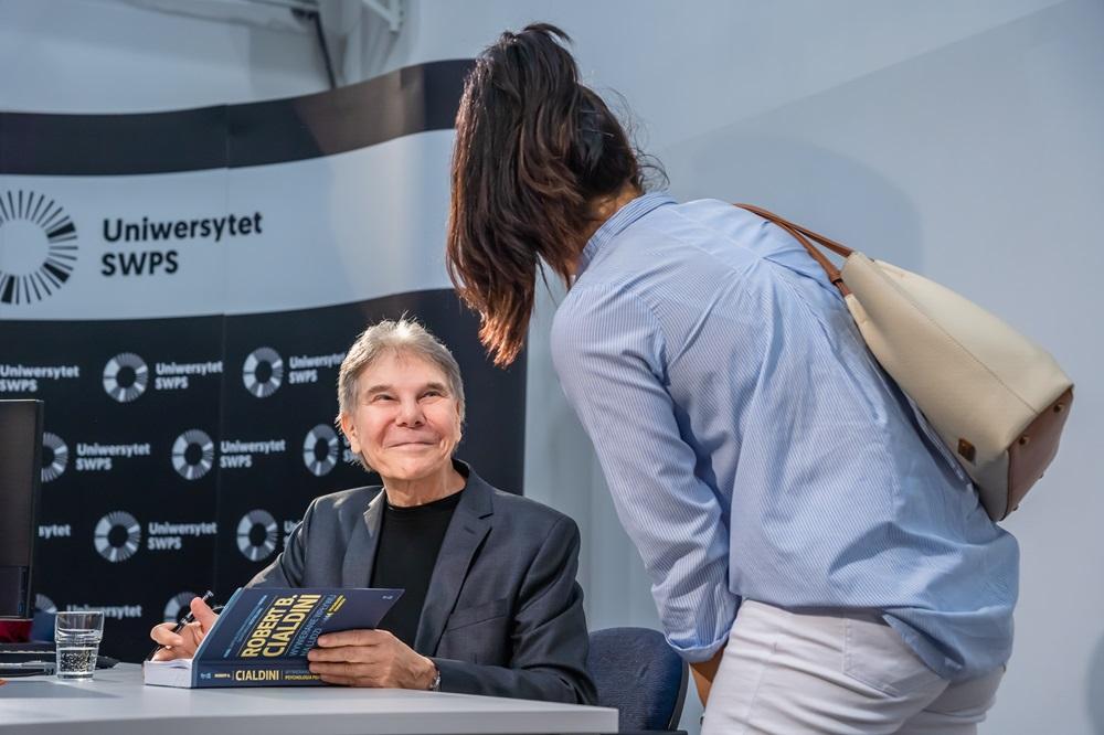 Profesor Caldini podpisujący swoją książkę dla studentki