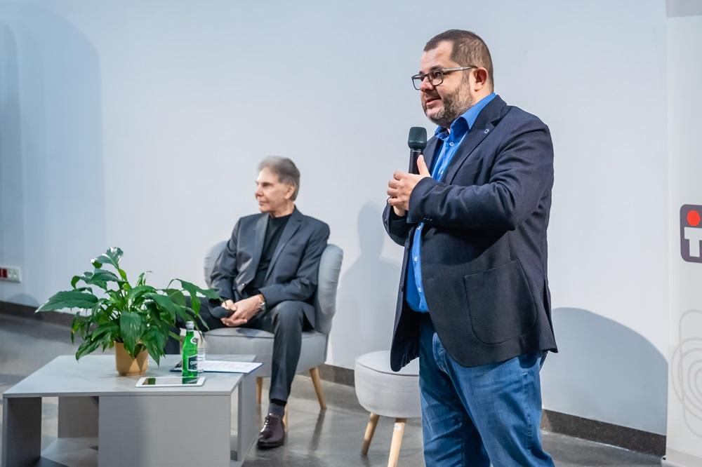 Zdjęcie panelu, na pierwszym plane stoi profesor Tomasz Grzyb z mikrofonem, w tle siedzi profesor Cialdini