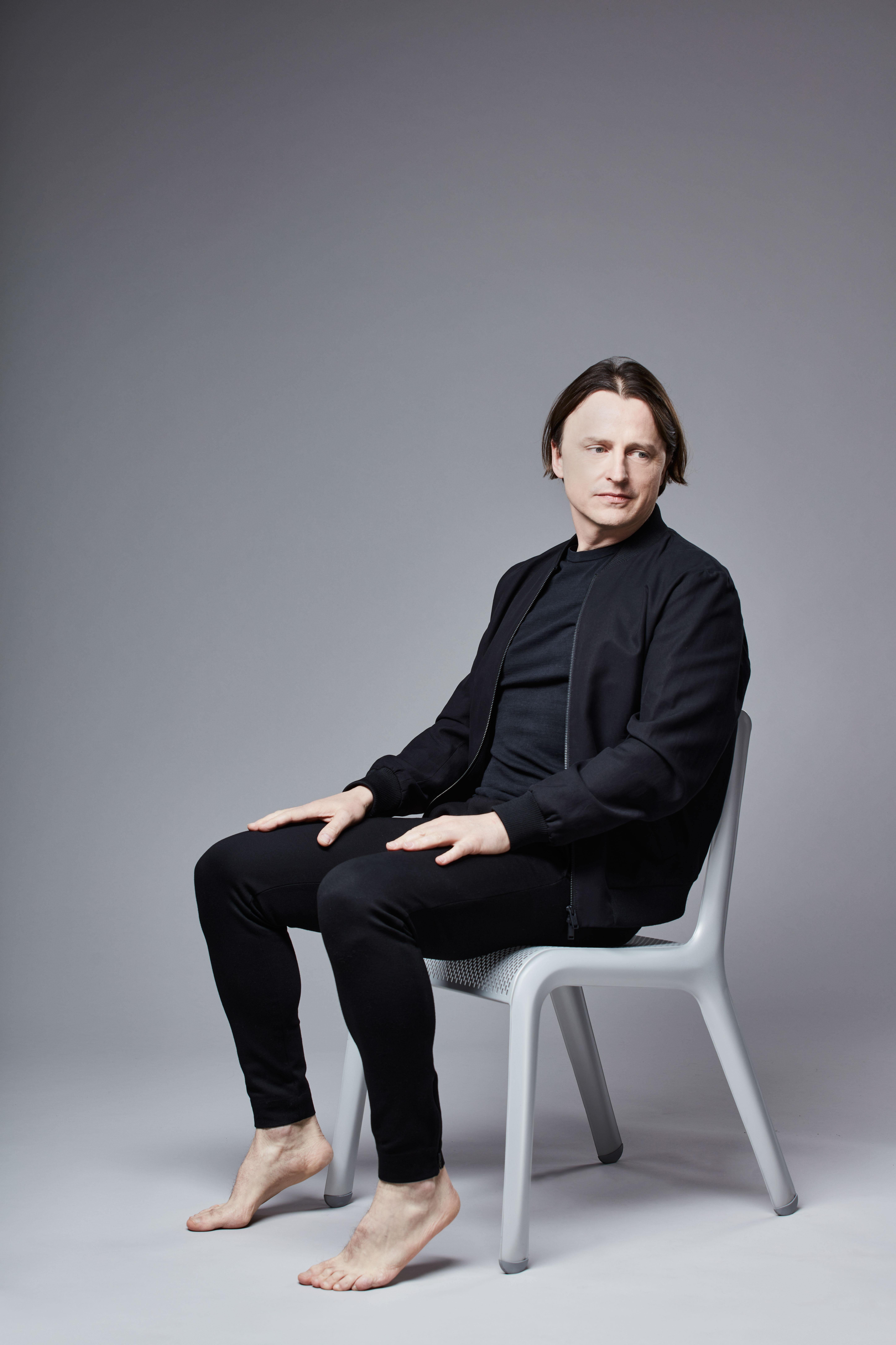 Oskar Zięta siedzący na zaprojektowanym przez siebie krześle Ultraleggera