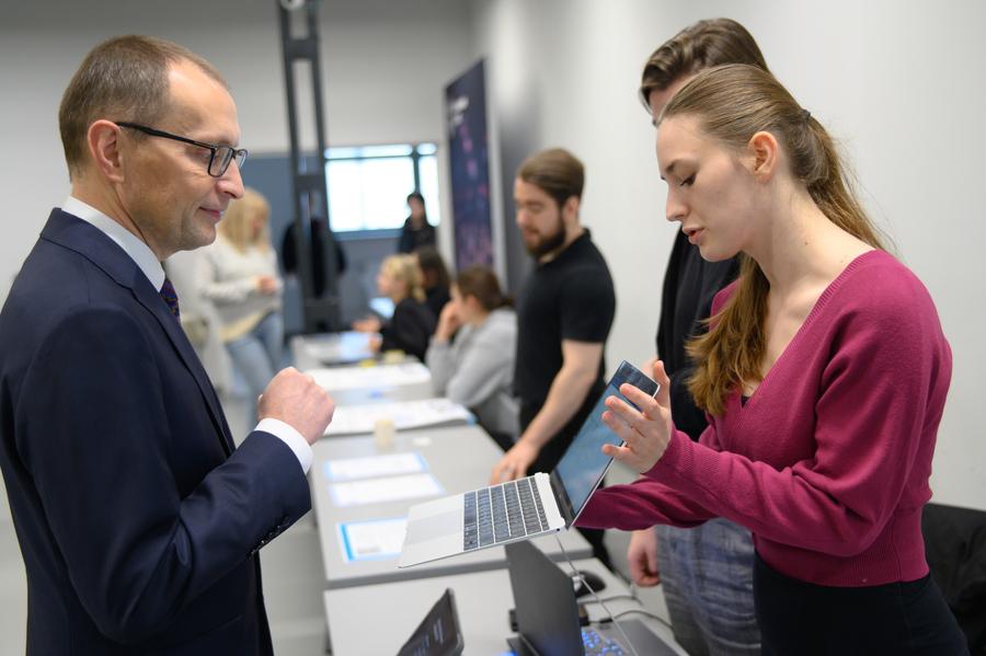 Studentka pokazuje rektorowi coś na ekranie laptopa