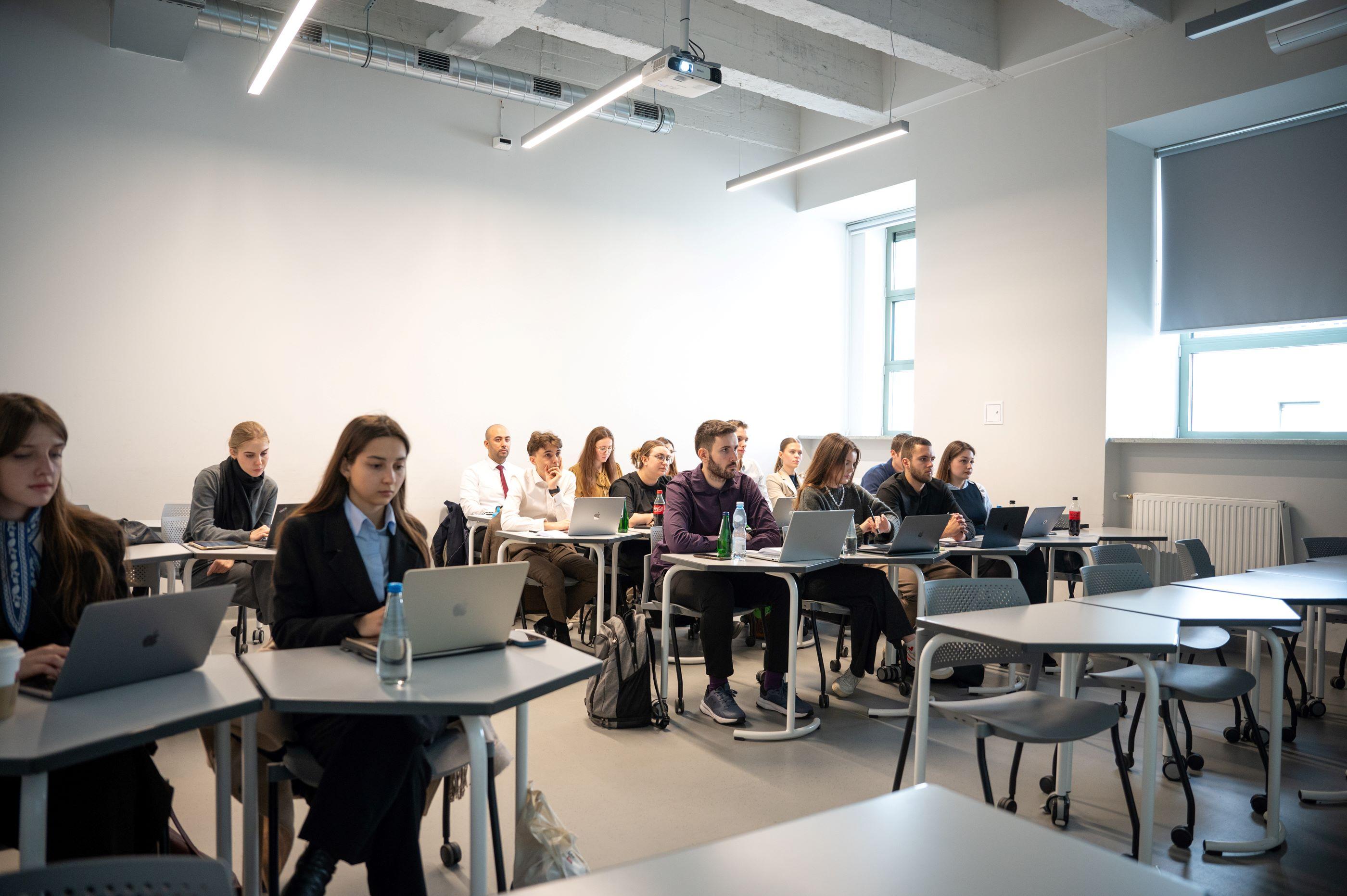 Uczestnicy bootcampu siedzą w sali i słuchają wykładu