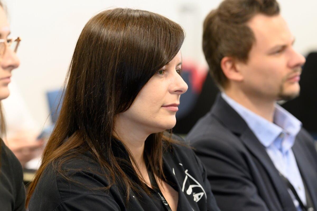 Kobieta i mężczyzna siedzą w publiczności konferencji "Innowacje społeczne" zorganizowanej przez Uniwersytet SWPS
