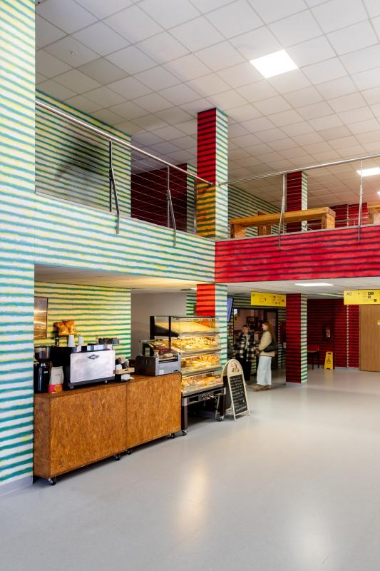 Mural Leona Tarasewicza na ścianach wewnątrz budynku Uniwersytetu SWPS; poziome pasy w kontrastujących kolorach