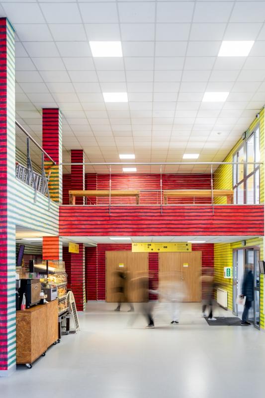 Mural Leona Tarasewicza na ścianach wewnątrz budynku Uniwersytetu SWPS; poziome pasy w kontrastujących kolorach